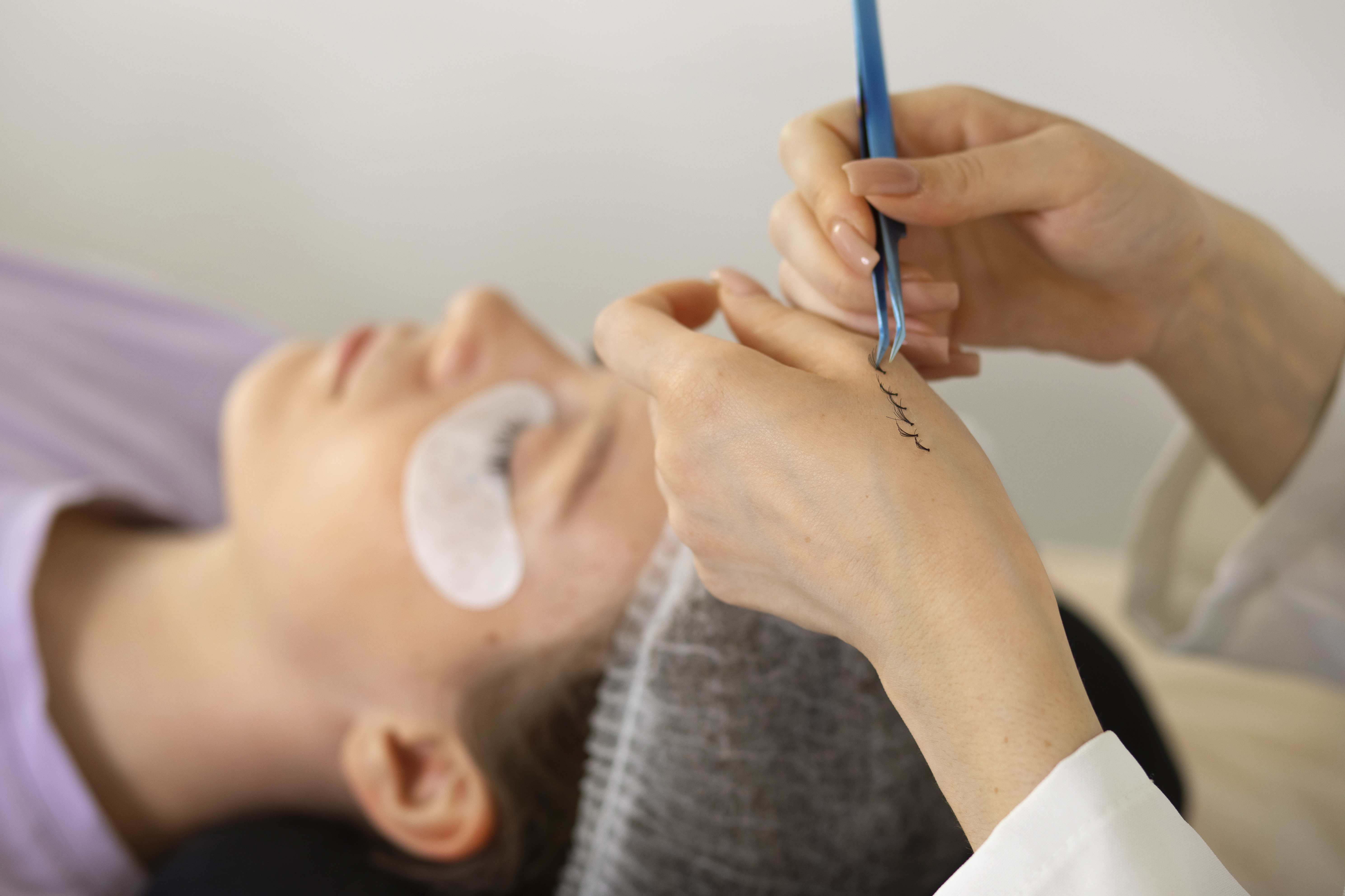 Detail profesionální lash artistka pracuje s umělými řasami